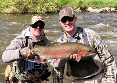 Guide Angelo Arias with a very happy client from a guided fly fishing trip to private water near Denver.